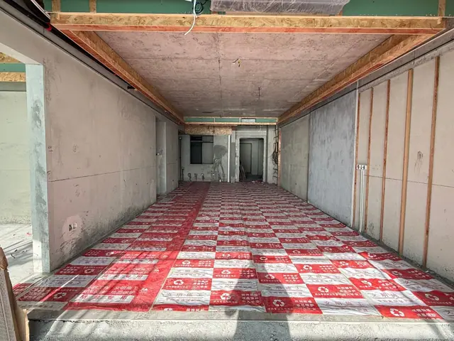An apartment in July 2026, plastered and with ceiling framing going in. Photo: Bayfancy